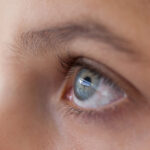 Close-up of girls eye and nose against white background