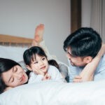 Happy family playing together in bedroom