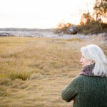 Woman standing on grass near the coast